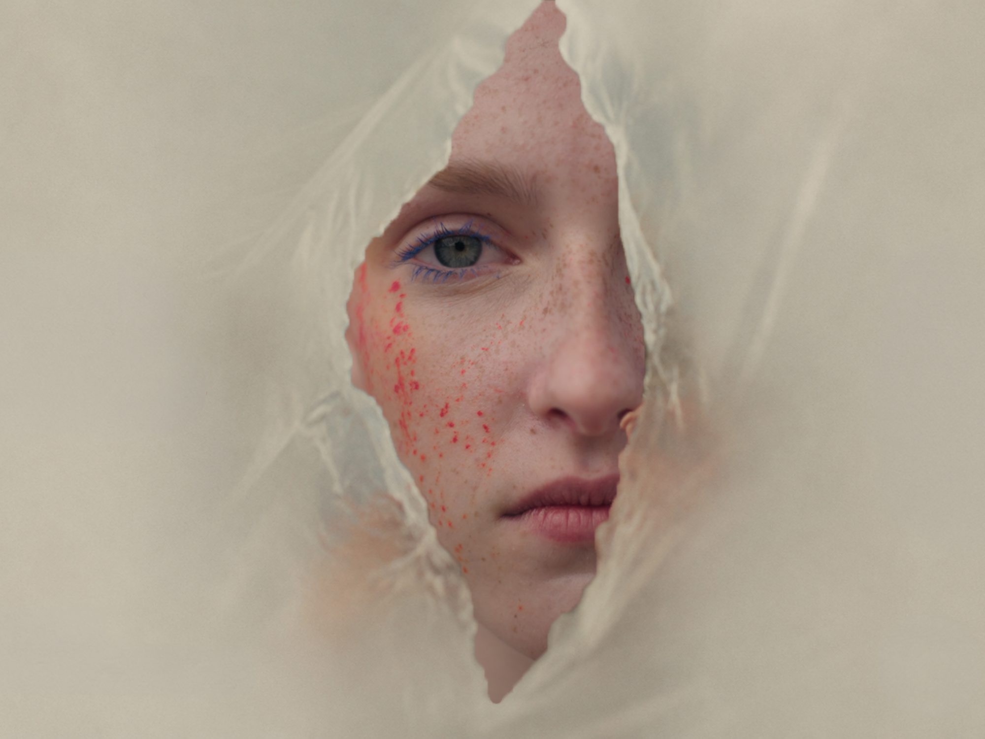 A face behind torn plastic